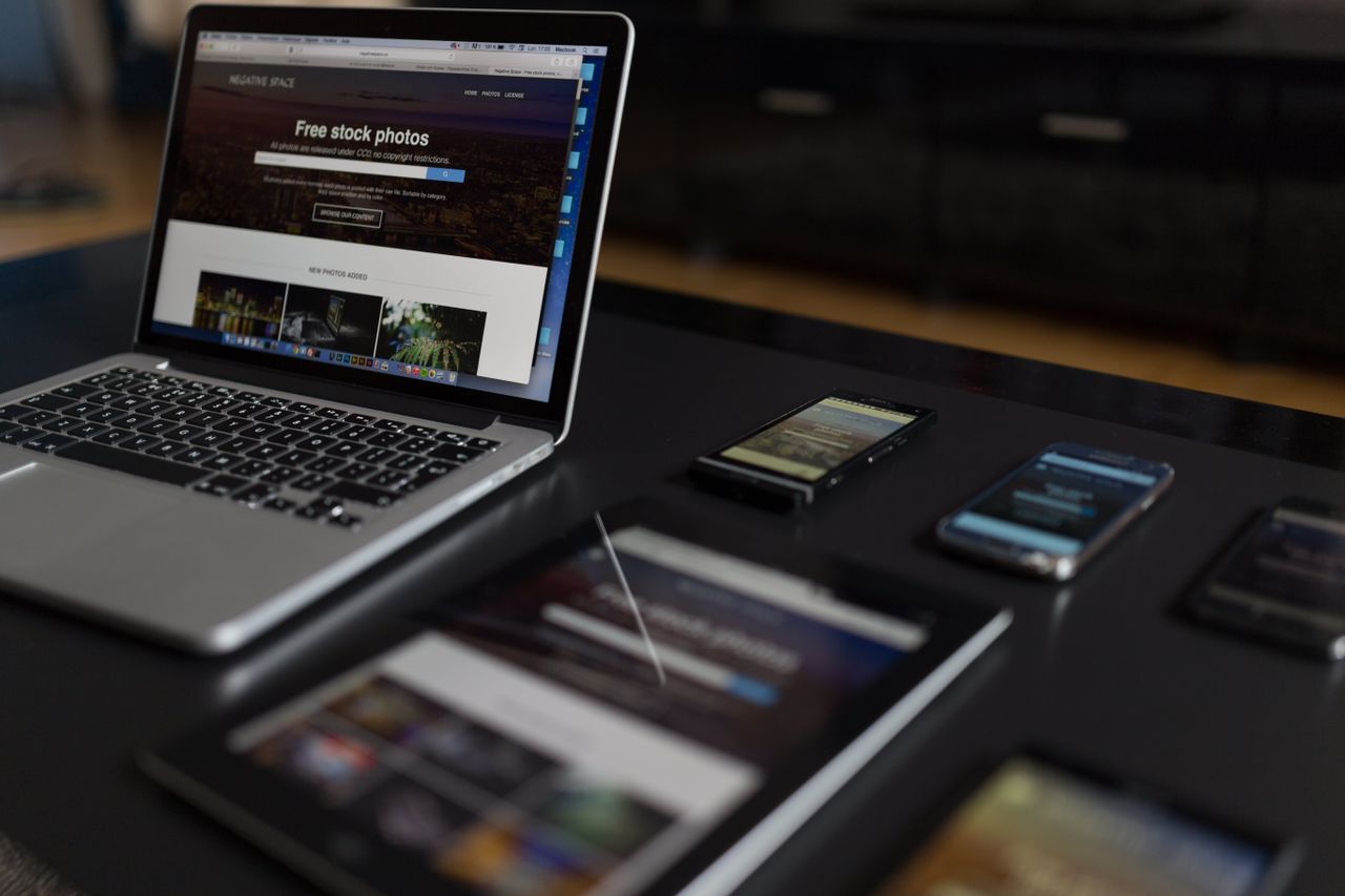 Un espace de travail contemporain présentant un ordinateur portable, une tablette et des smartphones, parfait pour un usage tech et freelance.
